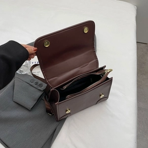 Internal view of dark brown leather backpack showing dual compartments and magnetic closure