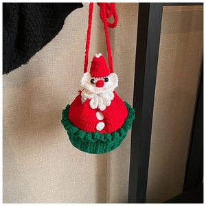 Detail of handmade crochet Santa Claus bag showing festive red and green yarn textures