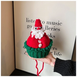 Detailed close-up of a handmade crochet Santa Claus shoulder bag with red and green yarns