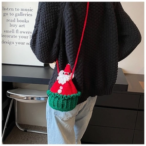 Detail of a handmade crochet Santa Claus crossbody bag with festive knit patterns