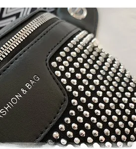 Detail of punk style black leather bag with silver studs and fashion brand engraving