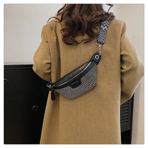 Close-up of black PU leather bag with silver studs and geometric pattern wide shoulder strap