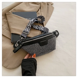 Detail of black faux leather bag with silver studs and geometric patterned strap
