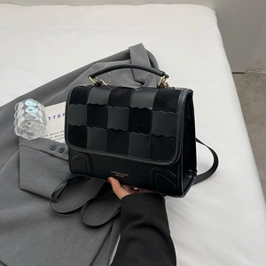 Vintage black crossbody bag featuring a checkerboard leather flap and gold hardware