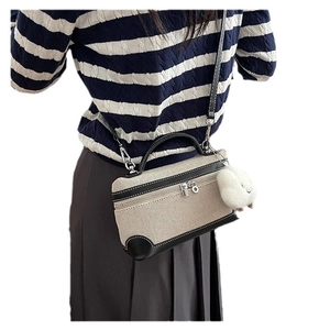 Retro canvas and black leather crossbody bag with fluffy charm shown on model