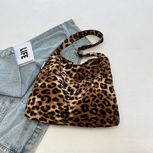 Detail der Leoparden-Einkaufstasche mit Webetikett auf hellblauem Denim-Stoff