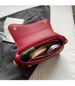 Top view of red lychee grain leather crossbody bag showing spacious interior and compartments