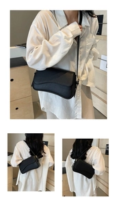 Detail of black lychee grain leather bag with wavy flap design and gold buckle strap