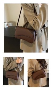Detail of dark brown lychee textured leather bag with wavy flap and gold hardware