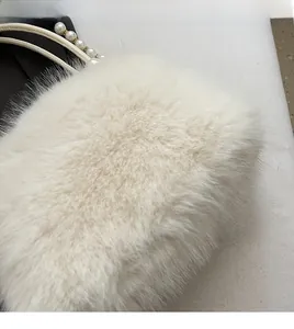 Détail de la texture en fausse fourrure blanche et poignée en perles élégante
