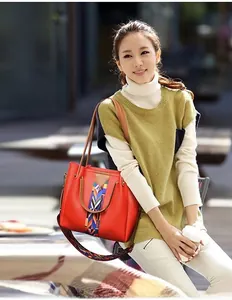 Detail of red PU leather tote with ethnic woven stripes and wide crossbody strap on model