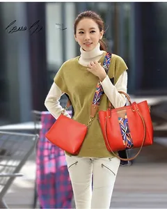 Detail of red PU leather tote with colorful ethnic woven shoulder strap on model