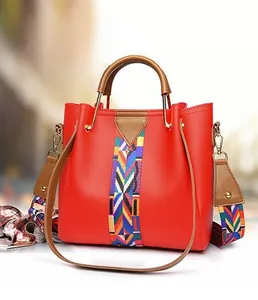 Detail of red PU leather tote with colorful geometric woven strap and top handle