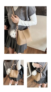 Detail of camel lychee grain leather bucket bag with silk scarf and plush monster charm