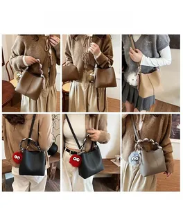 Detail of trendy bucket bags with metal ring handles and plush eye charms in four colors