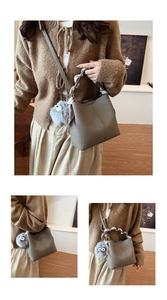 Detail of grey pebble leather bucket bag with printed silk scarf and plush monster charm