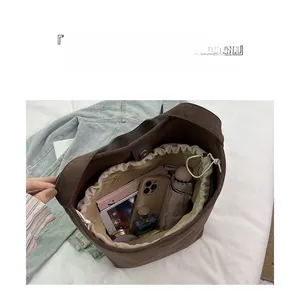 Macro view of brown suede bucket bag interior showing large capacity storage space