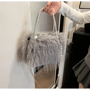 Détail de la texture en peluche grise avec anses en perles et bandoulière chaîne dorée