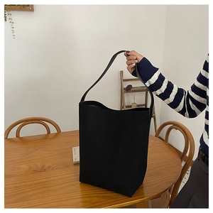Detail of minimalist black bucket bag showing spacious interior and premium matte texture