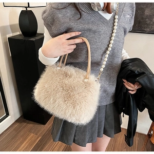 Détail du sac en fausse fourrure crème avec bandoulière en perles et poignées élégantes