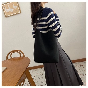 Close-up of the large black tote bag showing its spacious design and soft material texture