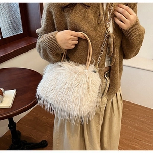 Détail du sac à main en fausse fourrure crème avec poignées cuir et chaîne dorée