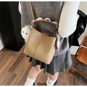 Detail of camel bucket bag with lychee texture leather and floral scarf handle wrap
