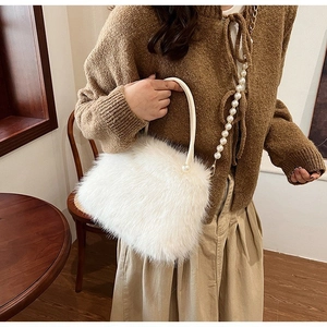 Détail du sac à main en fausse fourrure blanche avec bandoulière perles et texture douce