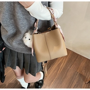 Chic khaki lychee leather bucket bag with floral silk scarf and plush monster charm
