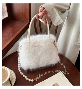 Gros plan sur le sac à main blanc en peluche avec perles et détail de chaîne dorée