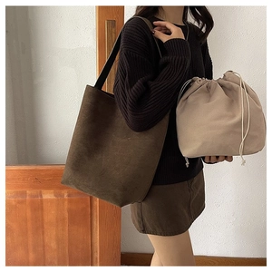 Brown frosted leather tote and beige drawstring bucket bag shown on a model