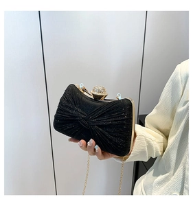 Détail de la pochette de soirée noire pailletée avec pli en nœud et fermoir boule cristal