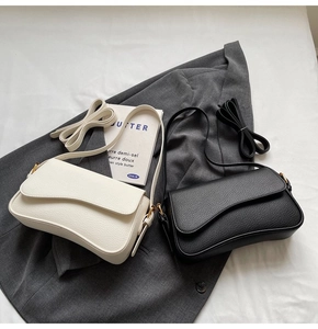 Detail of lychee textured leather bags with flap cover and minimalist gold buckles