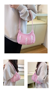Dettaglio borsa a mezzaluna in nylon rosa con frange di perline e tracolla sottile