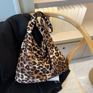 Modische Hobo-Tasche mit Leopardenmuster für Damen mit EMIS-Label an einem Holzstuhl hängend