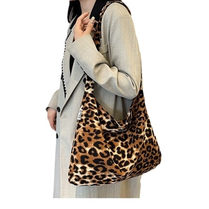 Klassische Shopper-Tasche mit Leopardenmuster und Markenetikett am Model gezeigt