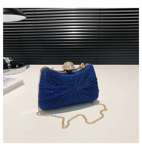 Détail de la pochette de soirée à paillettes bleu marine avec plis torsadés et fermoir cristal