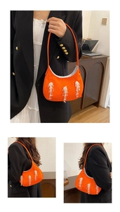 Dettaglio della borsa a mezzaluna in nylon arancione con eleganti nappe di perline bianche
