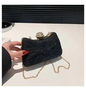 Vue détaillée du sac de soirée noir pailleté avec fermoir strass et plis en nœud