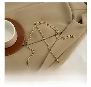 Detail of golden metal chain strap on a plush white and brown faux fur crossbody bag