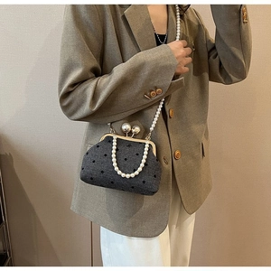 Close-up of pearl strap and metallic clasp on vintage polka dot crossbody bag