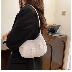 Dettaglio della borsa hobo con nappe di perline trasparenti e cuciture a contrasto