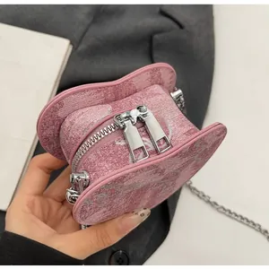 Detail of pink heart-shaped jacquard bag featuring smooth dual silver zippers and chain