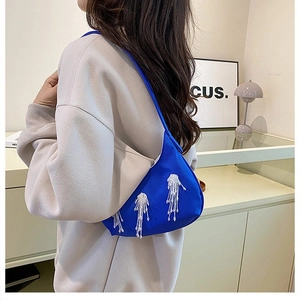 Dettaglio della borsa a spalla in raso blu brillante con nappe di perline bianche chic