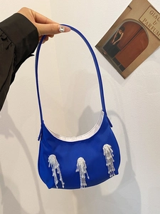 Dettaglio della borsa a mezzaluna in nylon blu brillante con nappe di perline d'argento