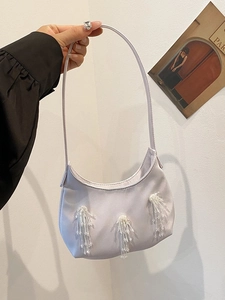 Dettaglio della borsa a tracolla in raso lavanda con nappine di perline bianche e zip