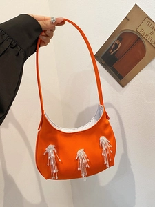 Dettaglio della borsa a mezzaluna arancione vivace con decorazione di frange di perline
