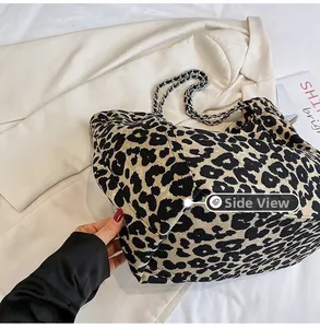 Side view of large leopard print canvas tote bag with metal and leather chain strap