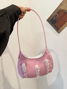 Dettaglio della borsa a tracolla in nylon rosa con frange di perline bianche sul lato