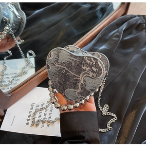 Detail of heart-shaped jacquard denim mini bag with silver beaded handle and chain